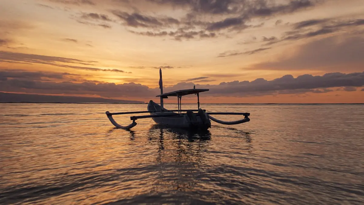 A liveaboard boat anchored on a wide stretch of clear water